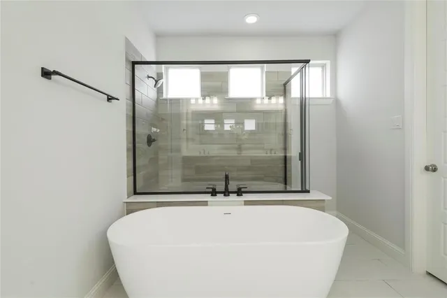a white bath tub sitting next to a shower