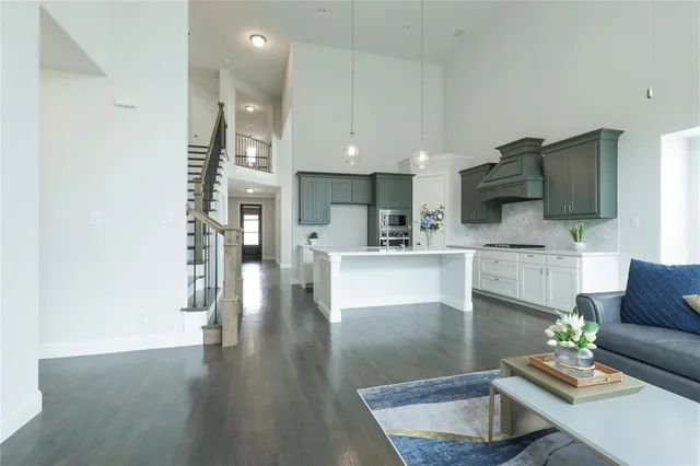a living room with furniture kitchen view and a wooden floor