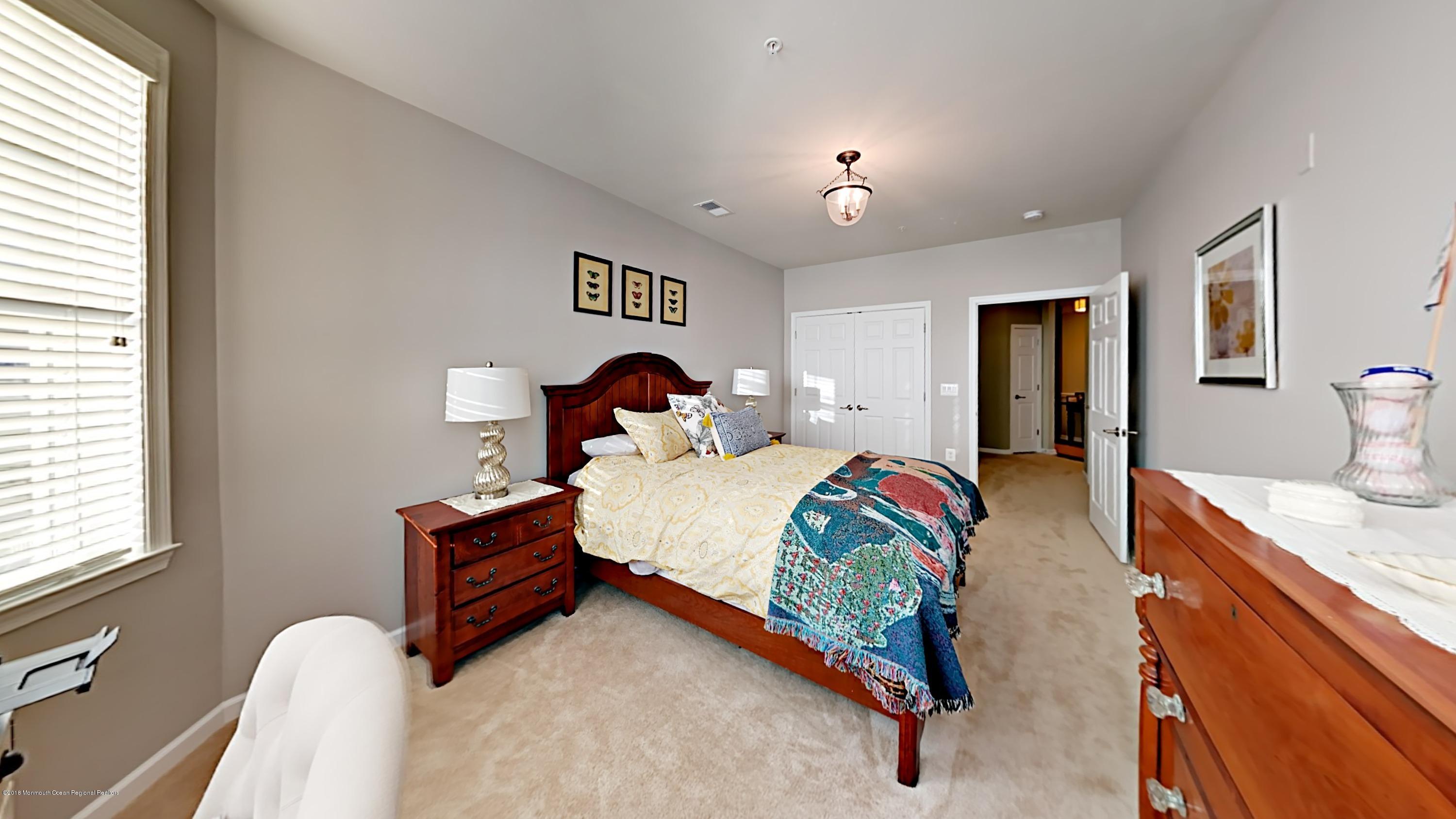 2201 River Road, Unit 4307 Point Pleasant, NJ 08742 - Photo 15 of 21 a bedroom with a bed and a chandelier
