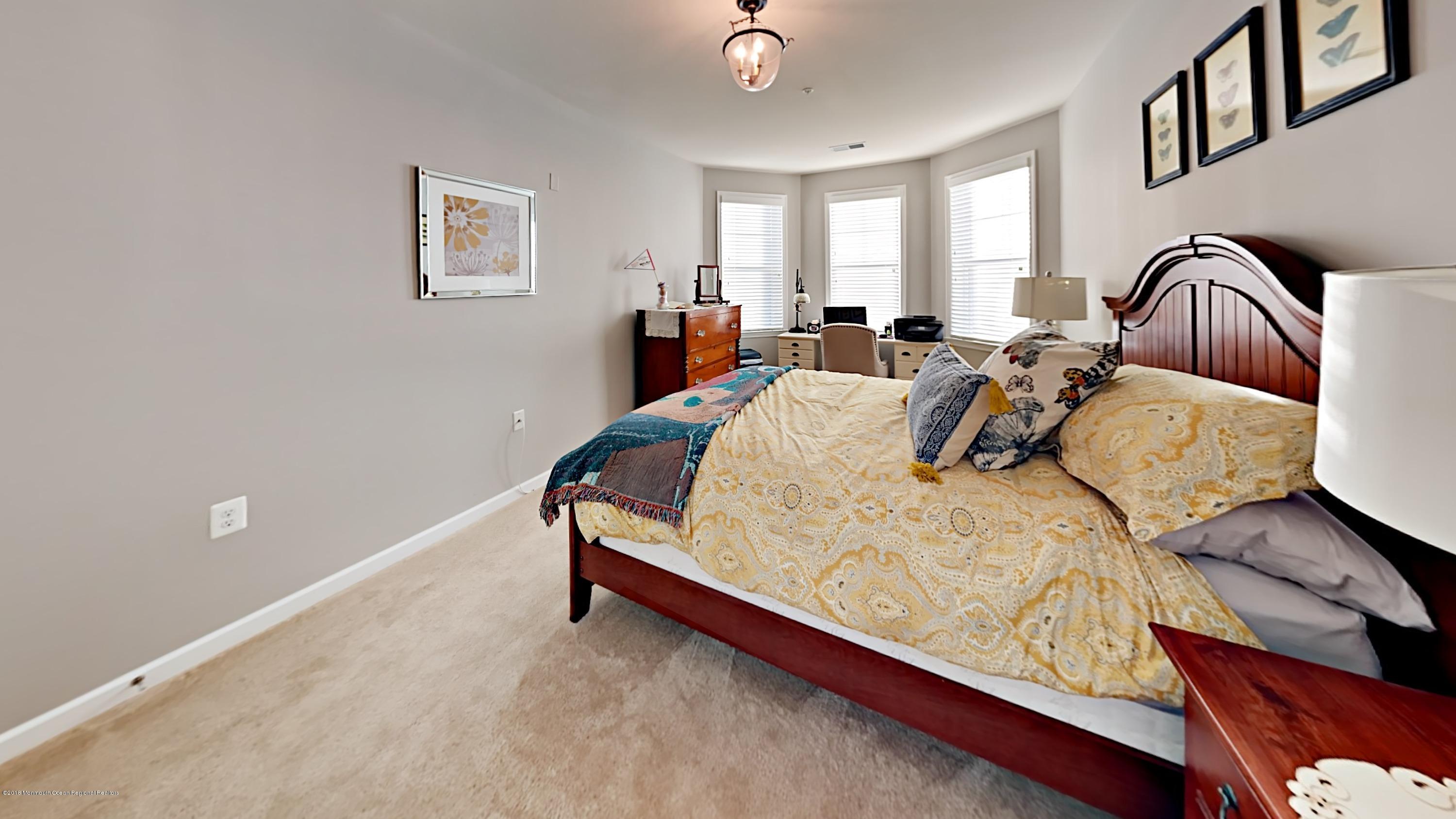 2201 River Road, Unit 4307 Point Pleasant, NJ 08742 - Photo 16 of 21 a bed sitting in a bedroom and chair