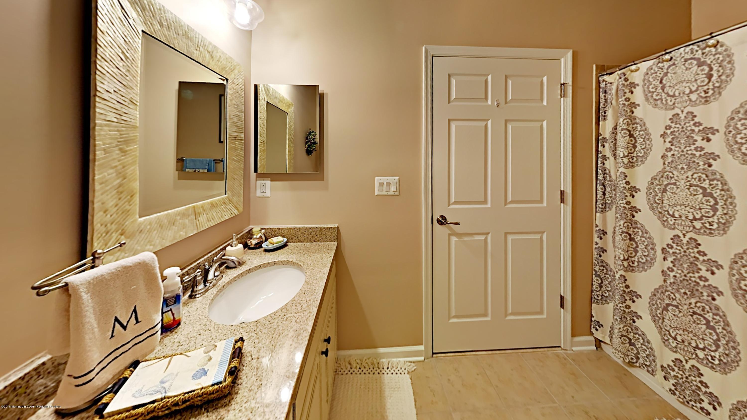 2201 River Road, Unit 4307 Point Pleasant, NJ 08742 - Photo 18 of 21 wooden bathroom with a sink and mirror