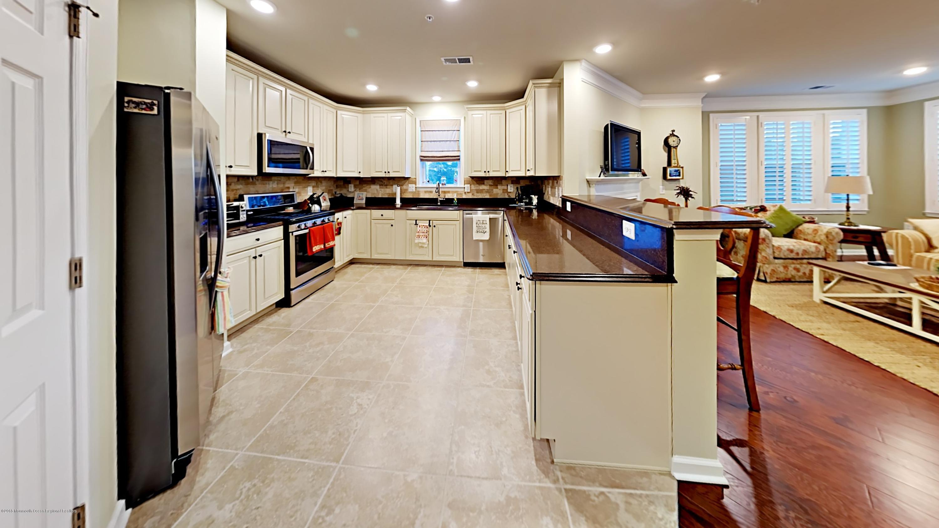 2201 River Road, Unit 4307 Point Pleasant, NJ 08742 - Photo 5 of 21 a kitchen with stainless steel appliances granite countertop a refrigerator sink and cabinets