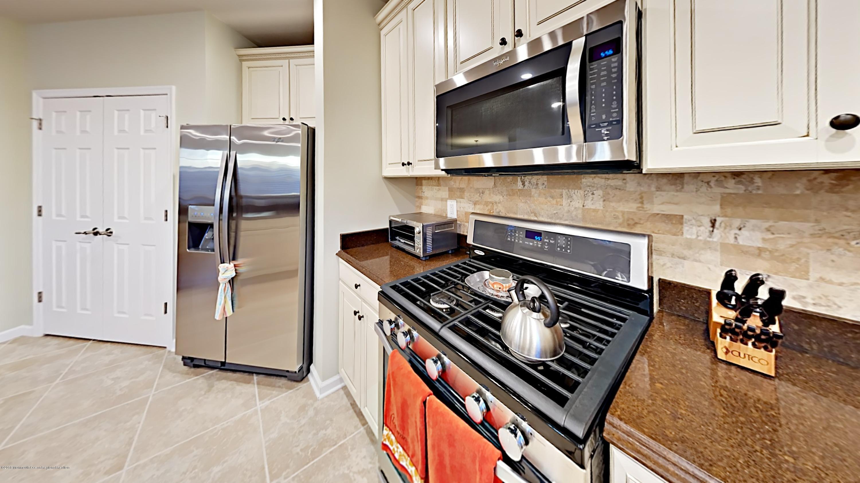 2201 River Road, Unit 4307 Point Pleasant, NJ 08742 - Photo 6 of 21 a kitchen with stainless steel appliances granite countertop a stove and a microwave