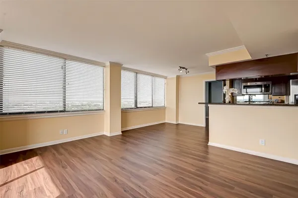 a view of a kitchen with wooden floor and a refrigerator
