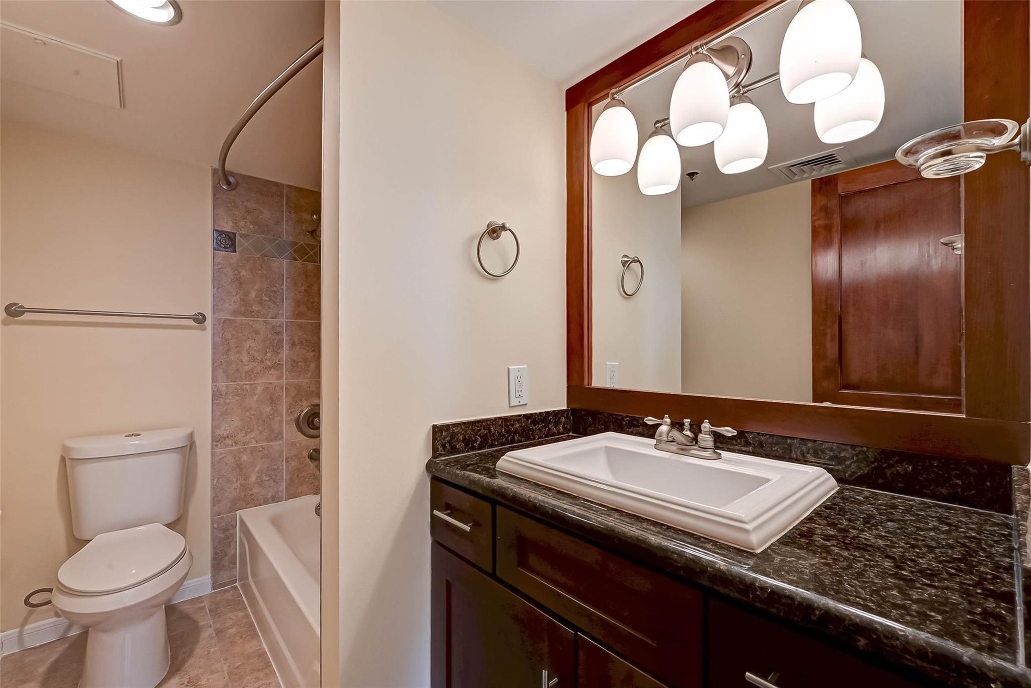 3525 Sage Road, Unit 1703 Houston, TX 77056 - Photo 32 of 43 a bathroom with a granite countertop sink toilet and a mirror