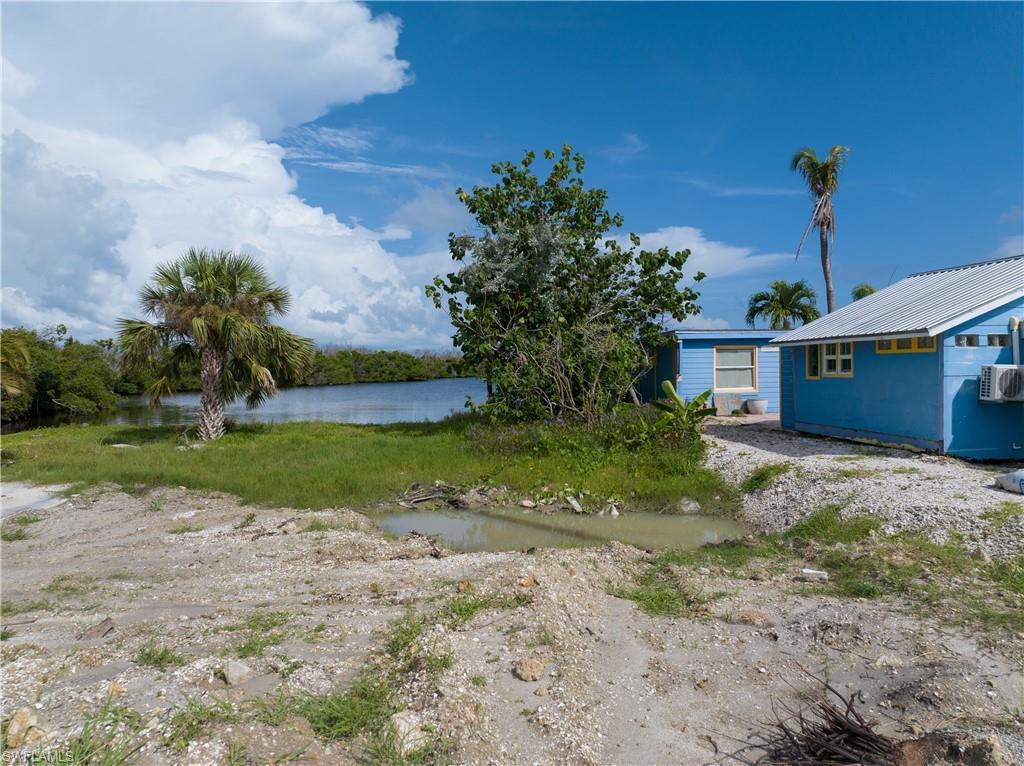 4850 Pine Island Road Bokeelia, FL 33922 - Photo 5 of 24 a view of a house with a yard and potted plants