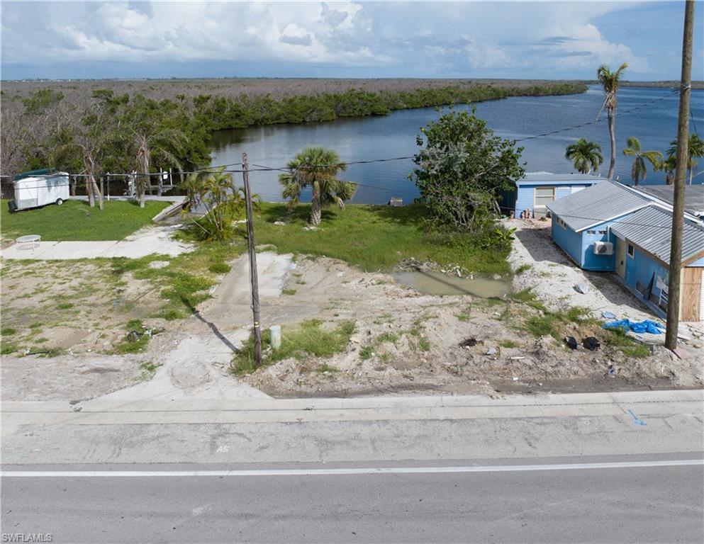 4850 Pine Island Road Bokeelia, FL 33922 - Photo 6 of 24 a view of a wooden house with a yard and potted plants