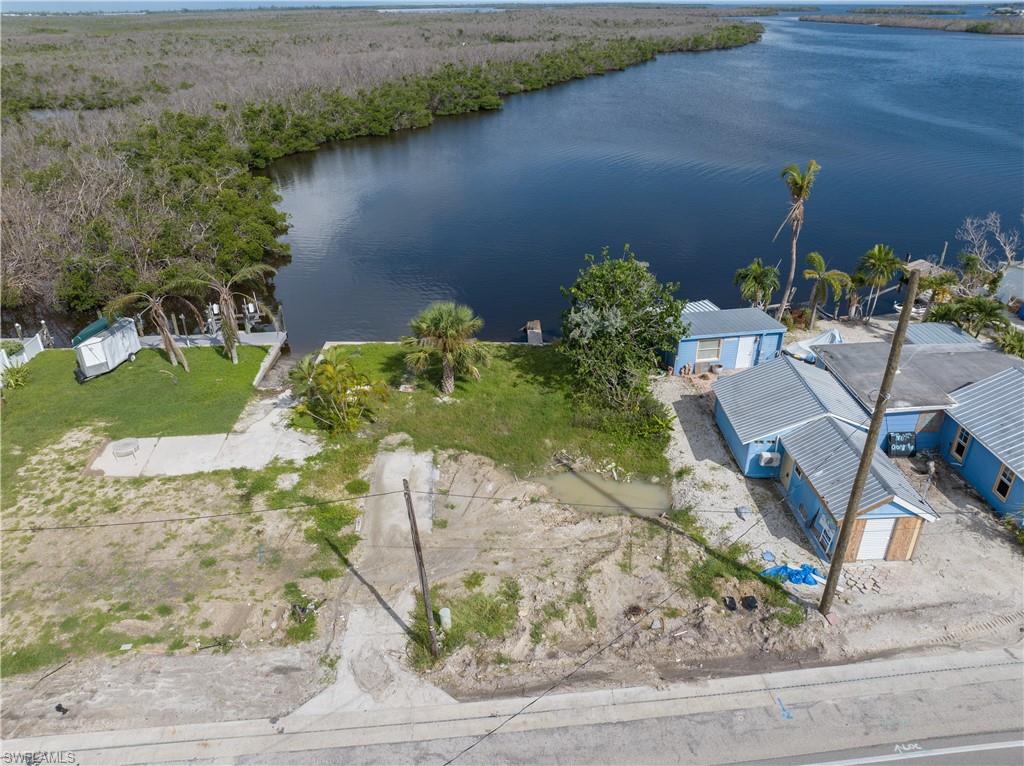 4850 Pine Island Road Bokeelia, FL 33922 - Photo 7 of 24 a view of a lake with a floor to ceiling window and wooden fence