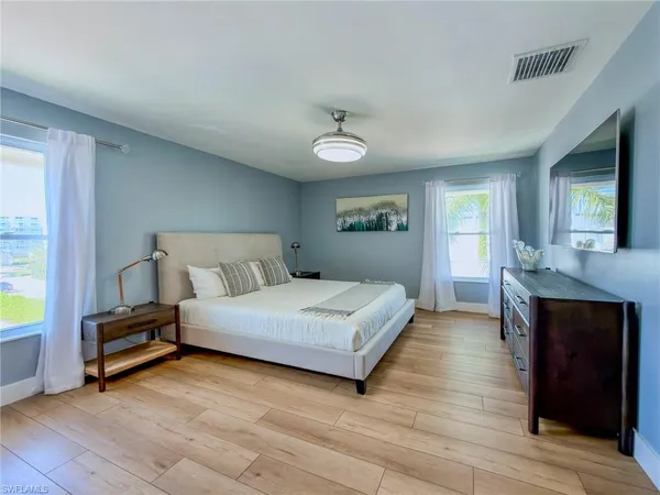 a spacious bedroom with a bed and a dresser in it