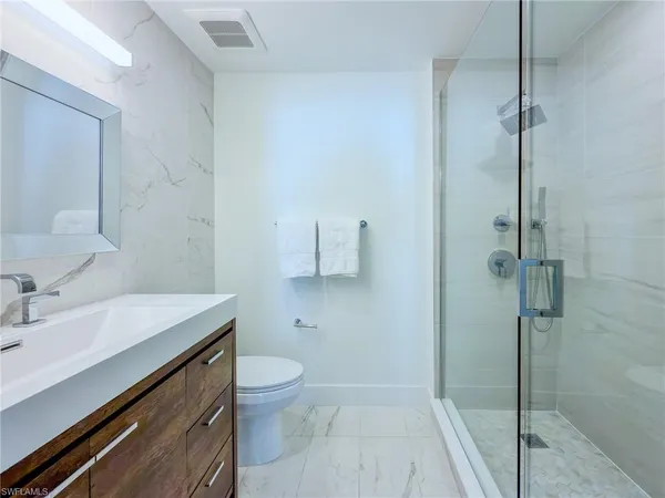 a bathroom with a sink a toilet and shower