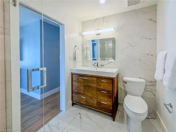 a bathroom with a toilet a sink and mirror
