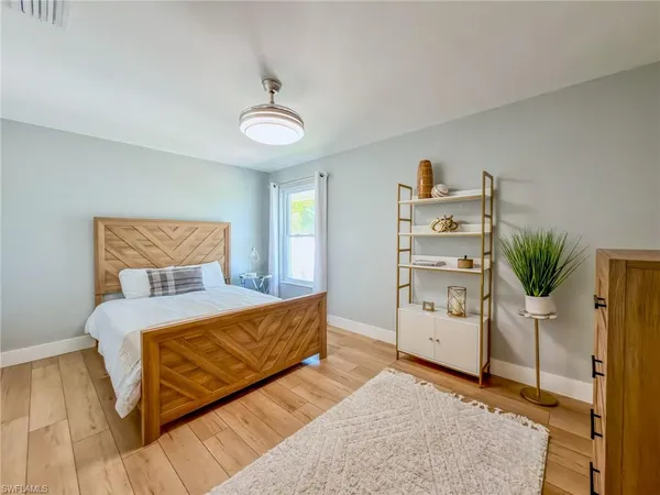 a bedroom with a bed chandelier and a window