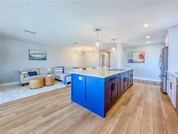 a large kitchen with stainless steel appliances a large counter top a sink and a wooden floors