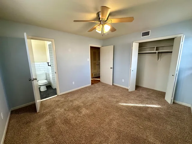 a view of a big room with closet and a chandelier fan