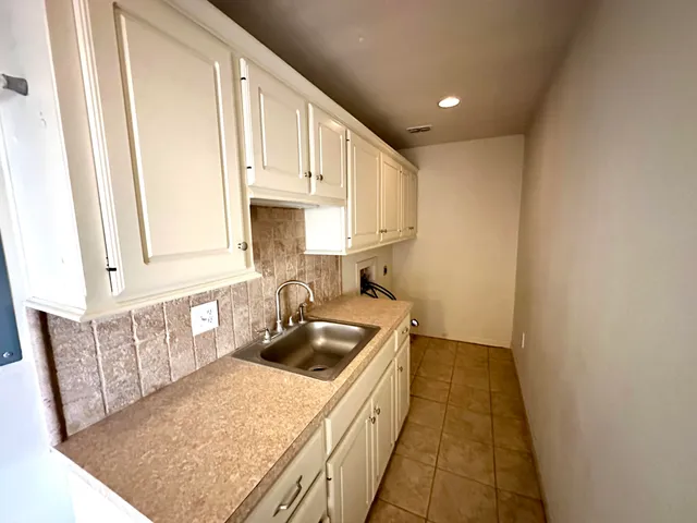 a kitchen with a sink a stove top oven and white kitchen