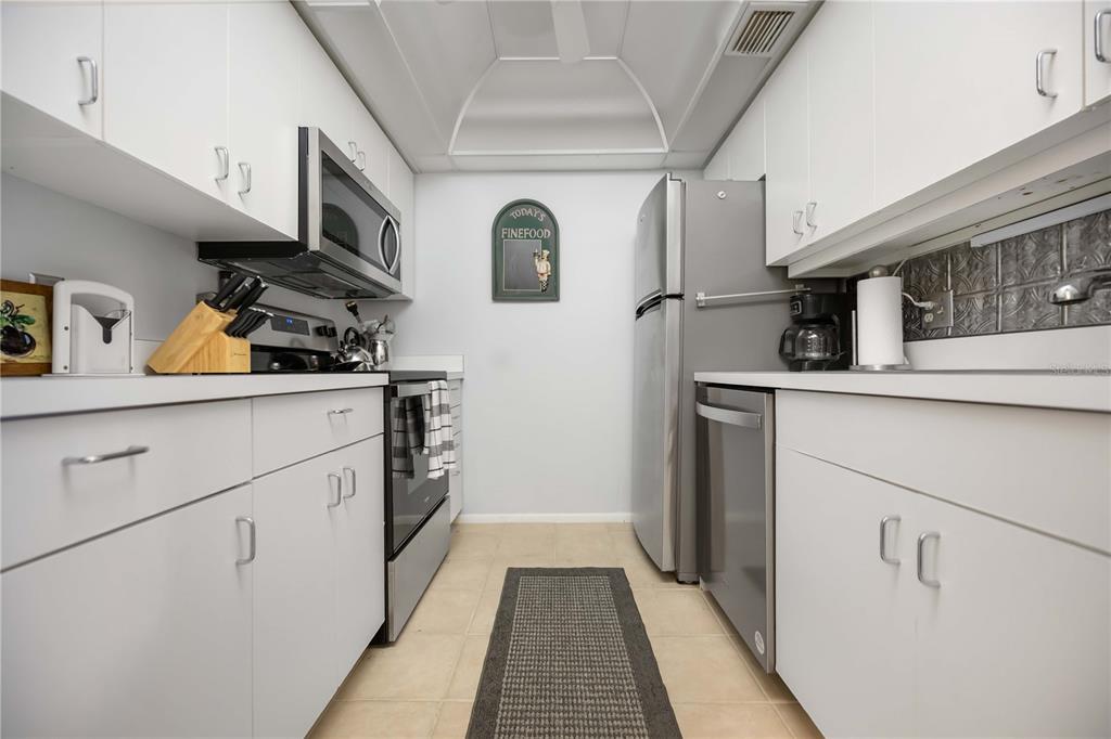 5631 Midnight Pass Road, Unit 1002 Sarasota, FL 34242 - Photo 11 of 30 a kitchen with stainless steel appliances granite countertop a refrigerator and a stove