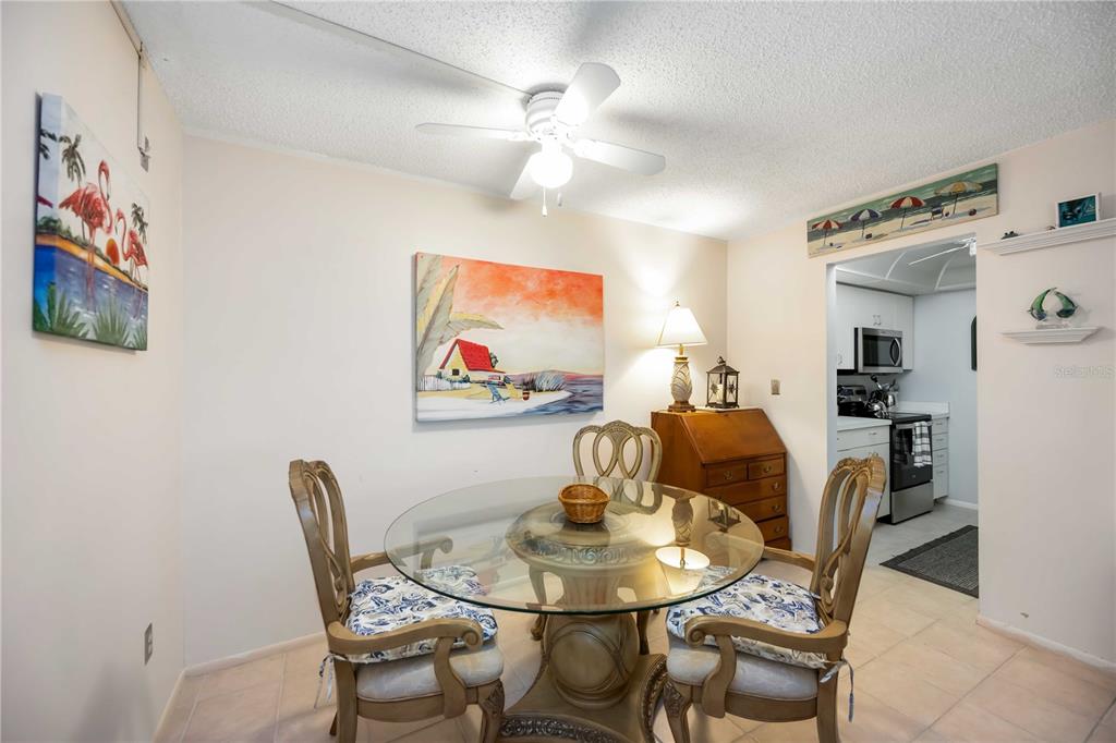 5631 Midnight Pass Road, Unit 1002 Sarasota, FL 34242 - Photo 13 of 30 a view of a dining room with furniture and chandelier