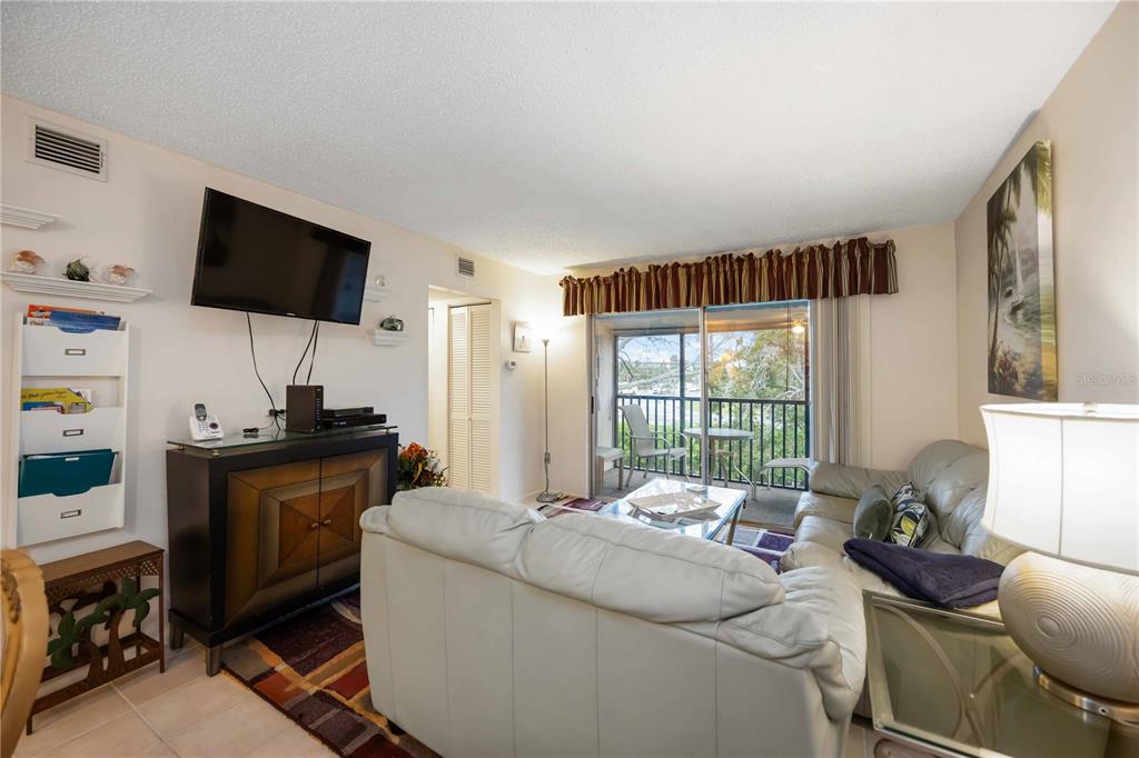 5631 Midnight Pass Road, Unit 1002 Sarasota, FL 34242 - Photo 16 of 30 a living room with furniture and a flat screen tv