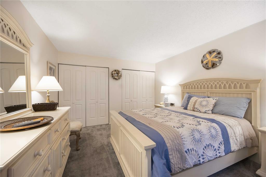 5631 Midnight Pass Road, Unit 1002 Sarasota, FL 34242 - Photo 18 of 30 a spacious bedroom with a bed and a chandelier