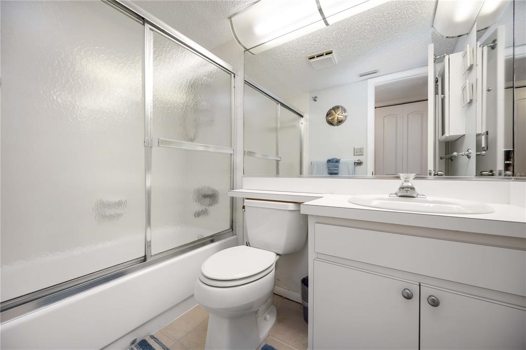 5631 Midnight Pass Road, Unit 1002 Sarasota, FL 34242 - Photo 22 of 30 a bathroom with a toilet a sink and shower