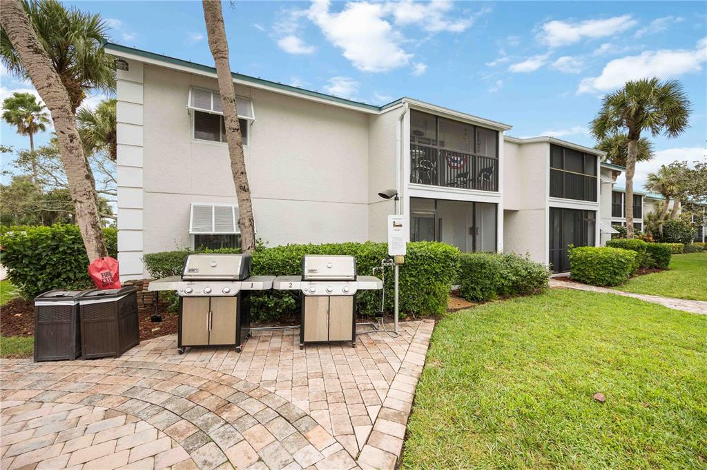 5631 Midnight Pass Road, Unit 1002 Sarasota, FL 34242 - Photo 25 of 30 a view of a patio with table and chairs and potted plants