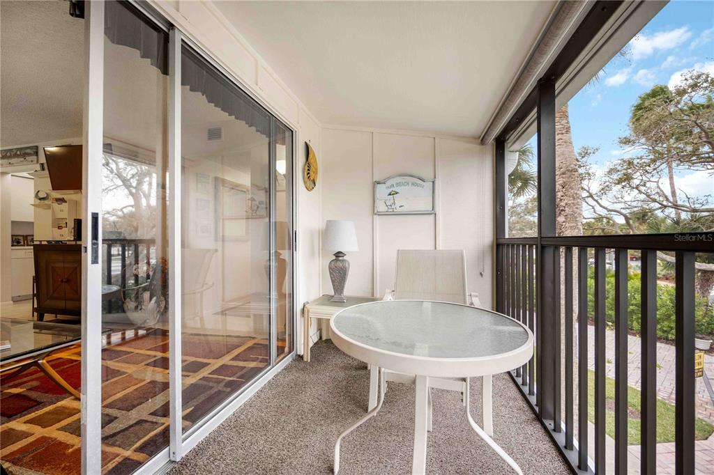 5631 Midnight Pass Road, Unit 1002 Sarasota, FL 34242 - Photo 26 of 30 a balcony with table and chairs