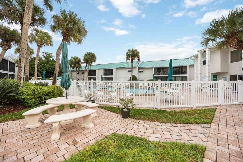 5631 Midnight Pass Road, Unit 1002 Sarasota, FL 34242 - Photo 29 of 30 a front view of a house with a garden and plants