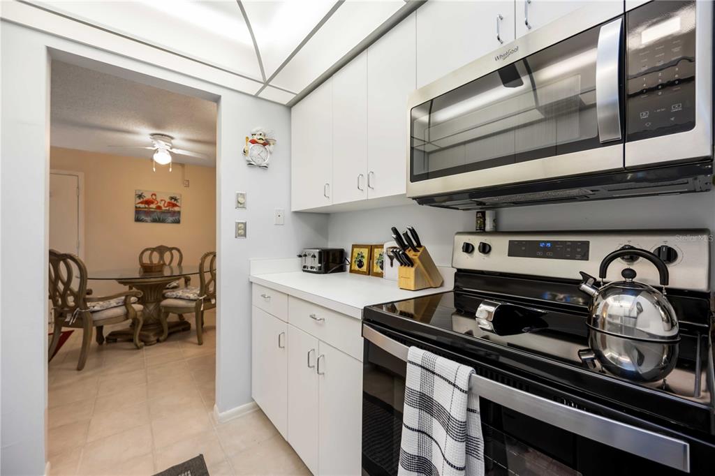 5631 Midnight Pass Road, Unit 1002 Sarasota, FL 34242 - Photo 8 of 30 a kitchen with a stove and a microwave