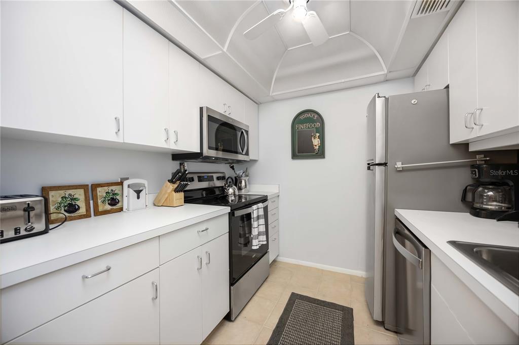 5631 Midnight Pass Road, Unit 1002 Sarasota, FL 34242 - Photo 10 of 30 a kitchen with a sink a stove and refrigerator
