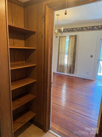 a view of a hallway with wooden floor and staircase