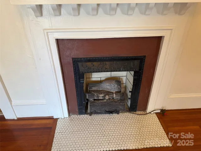 a view of an empty room with a fireplace and a window