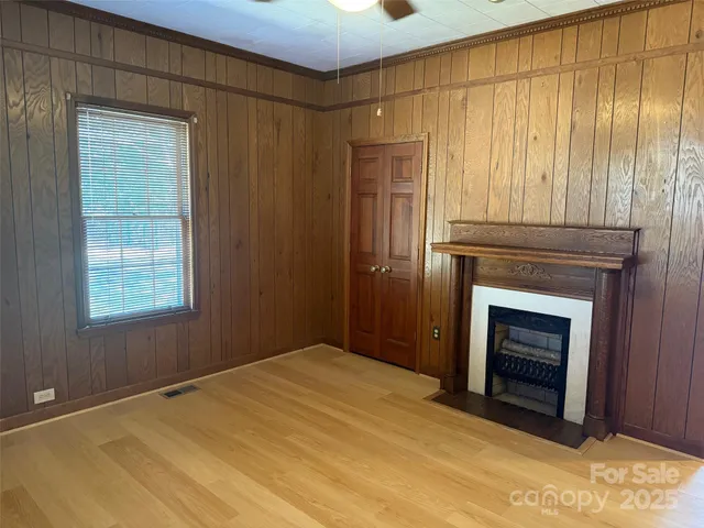 a view of an empty room with a fireplace and a window