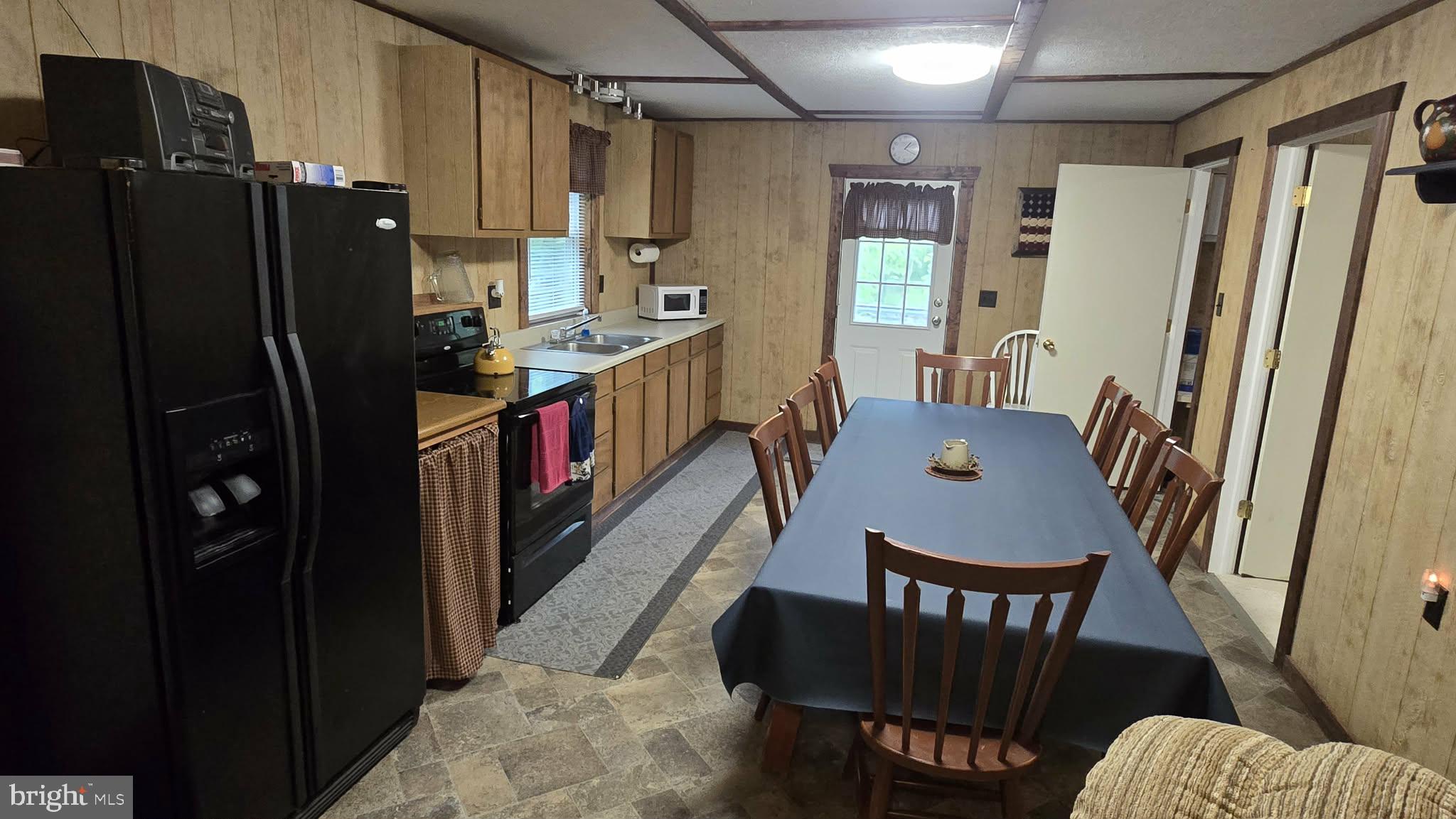 8245 Aughwick Road Fort Loudon, PA 17224 - Photo 8 of 26 a kitchen with stainless steel appliances granite countertop a refrigerator a stove a sink dishwasher and a dining table with wooden floor