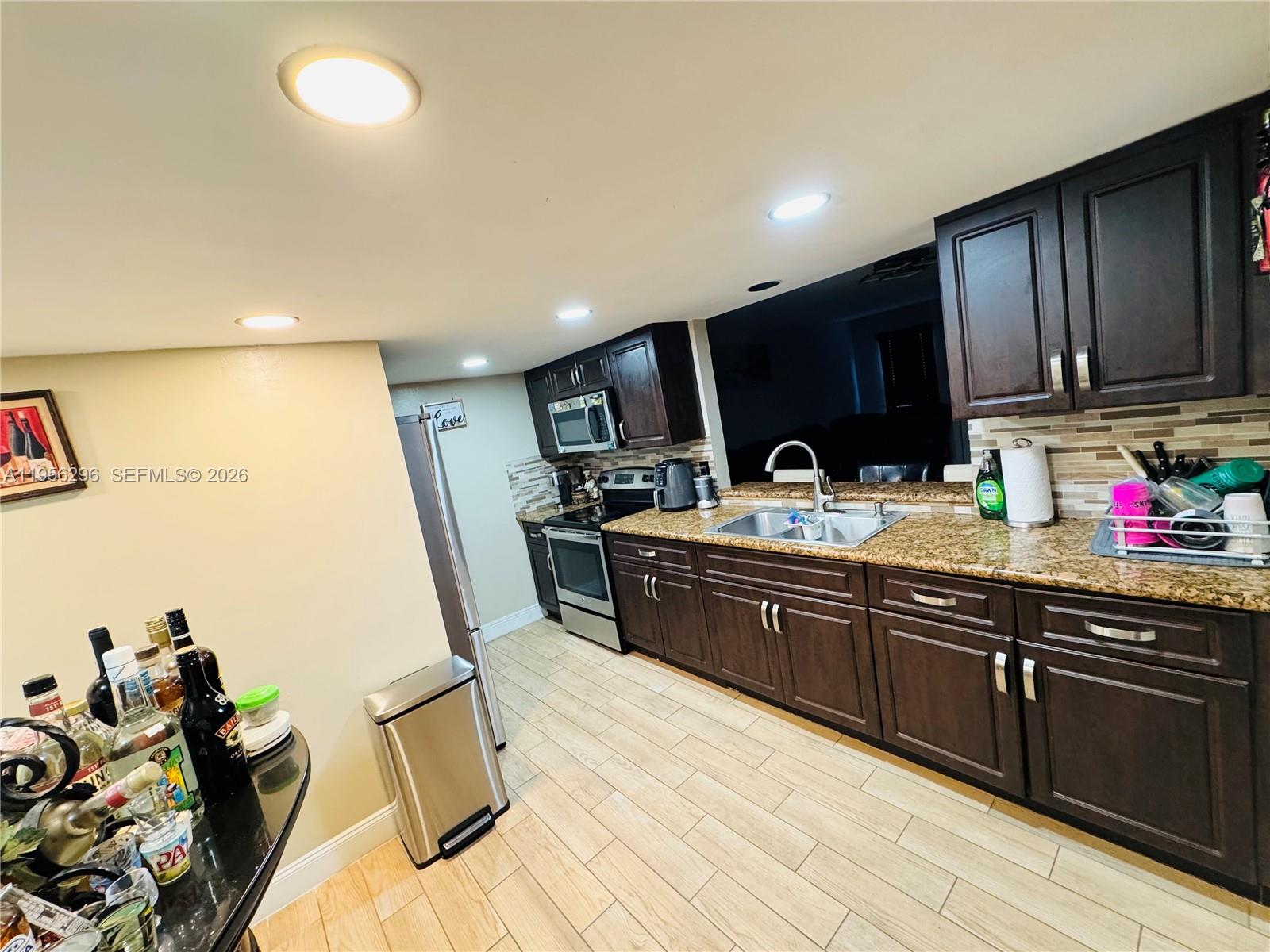 9412 Northwest 39th Street Sunrise, FL 33351 - Photo 20 of 23 a kitchen with granite countertop a sink cabinets and wooden floor
