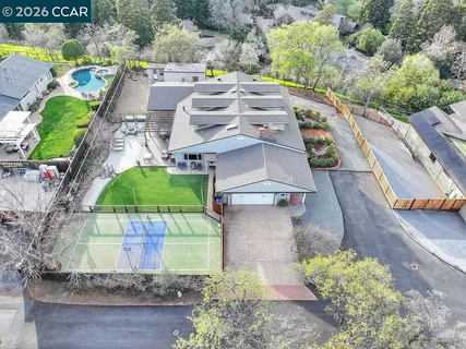 an aerial view of a house with a yard and lake view