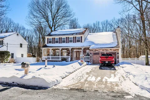 a living room with furniture kitchen view and a large window