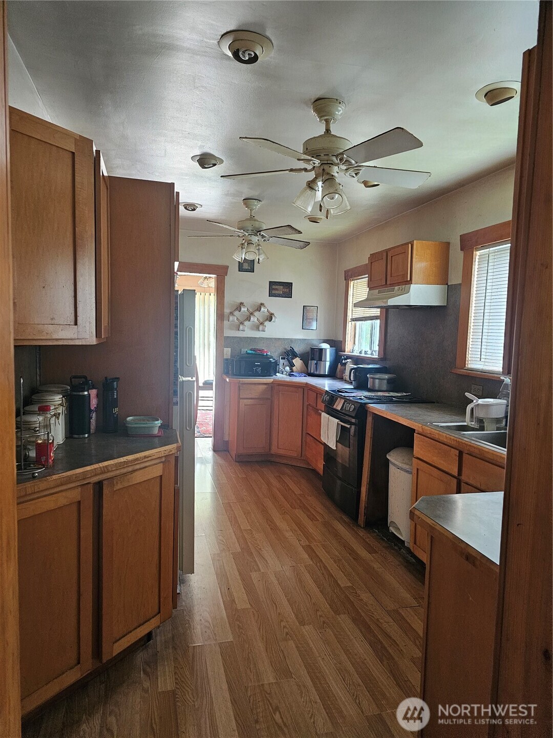 5390 Highway 12 Elma, WA 98541 - Photo 8 of 12 a large kitchen with stainless steel appliances granite countertop a refrigerator a sink dishwasher a stove and white countertops with wooden floor