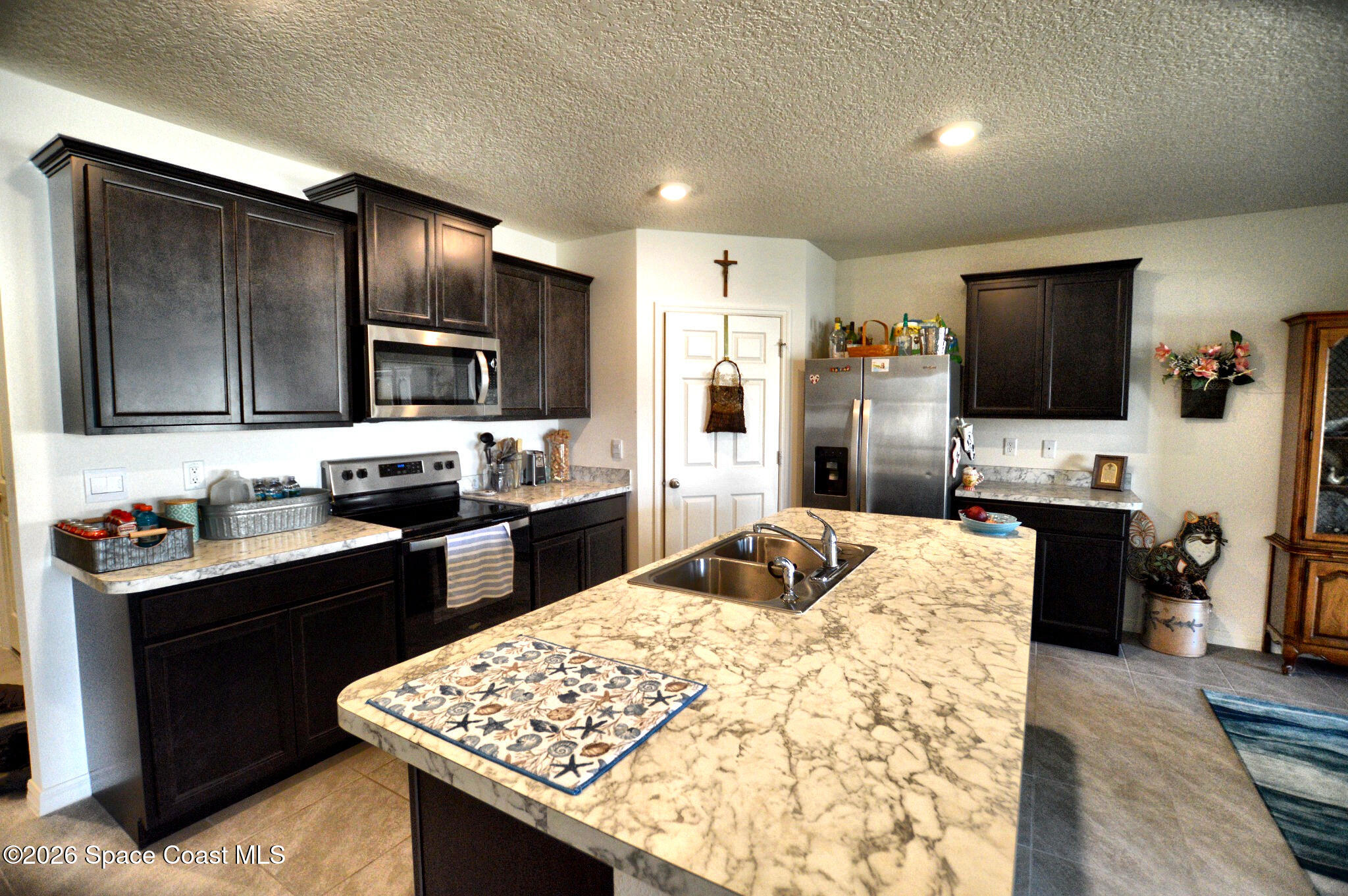 977 Trinity Street Rockledge, FL 32955 - Photo 8 of 18 a kitchen with stainless steel appliances kitchen island granite countertop a sink stove and refrigerator