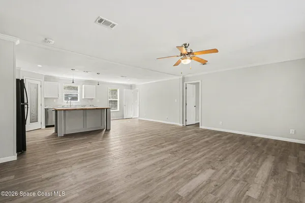 a view of an empty room with a kitchen