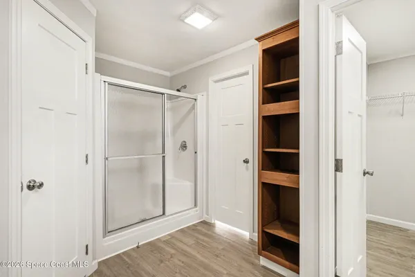 a view of walk in closet with wooden floor