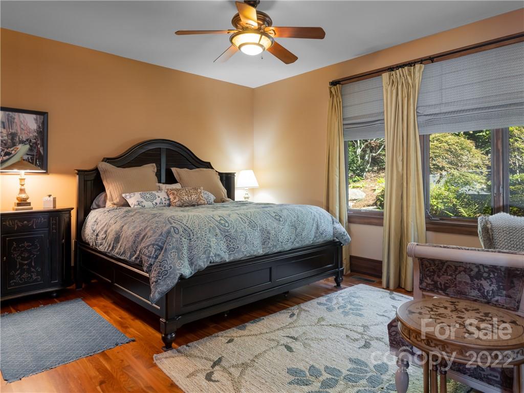 168 Pinkerton Corner Fairview, NC 28730 - Photo 28 of 48 a bedroom with a bed and a dresser next to a window