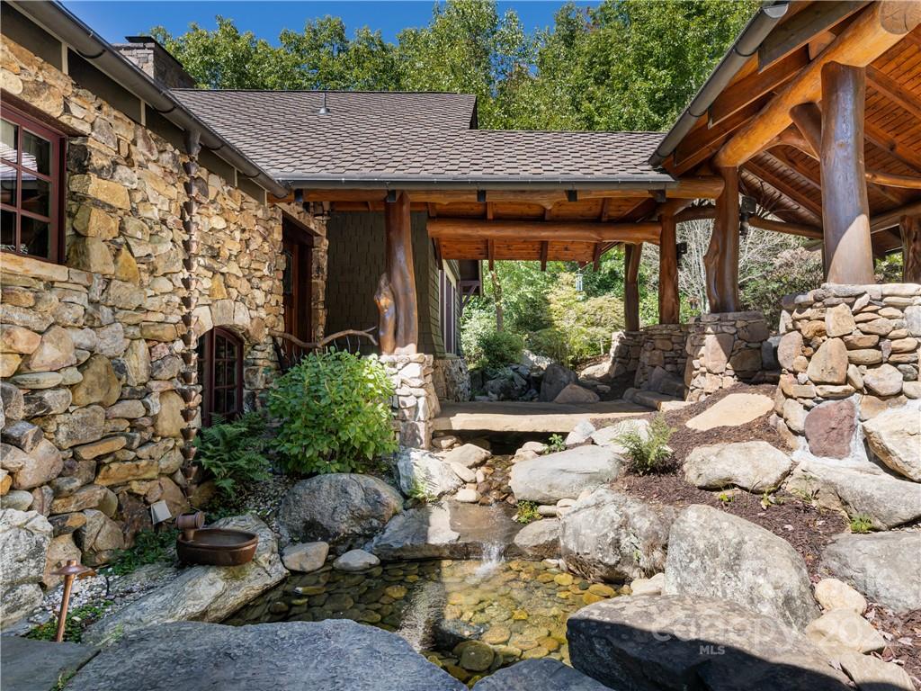 168 Pinkerton Corner Fairview, NC 28730 - Photo 3 of 48 a backyard of a house with large trees and outdoor seating