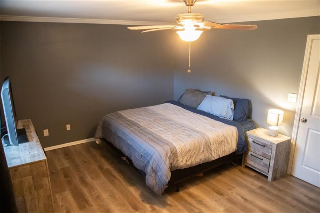 571 Oak Grove Road McDonough, GA 30253 - Photo 17 of 31 a bedroom with a bed and dresser with wooden floor