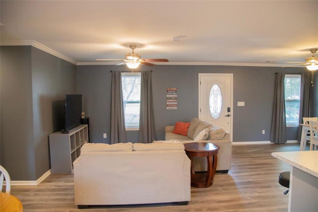571 Oak Grove Road McDonough, GA 30253 - Photo 6 of 31 a living room with furniture a flat screen tv and a wooden floor