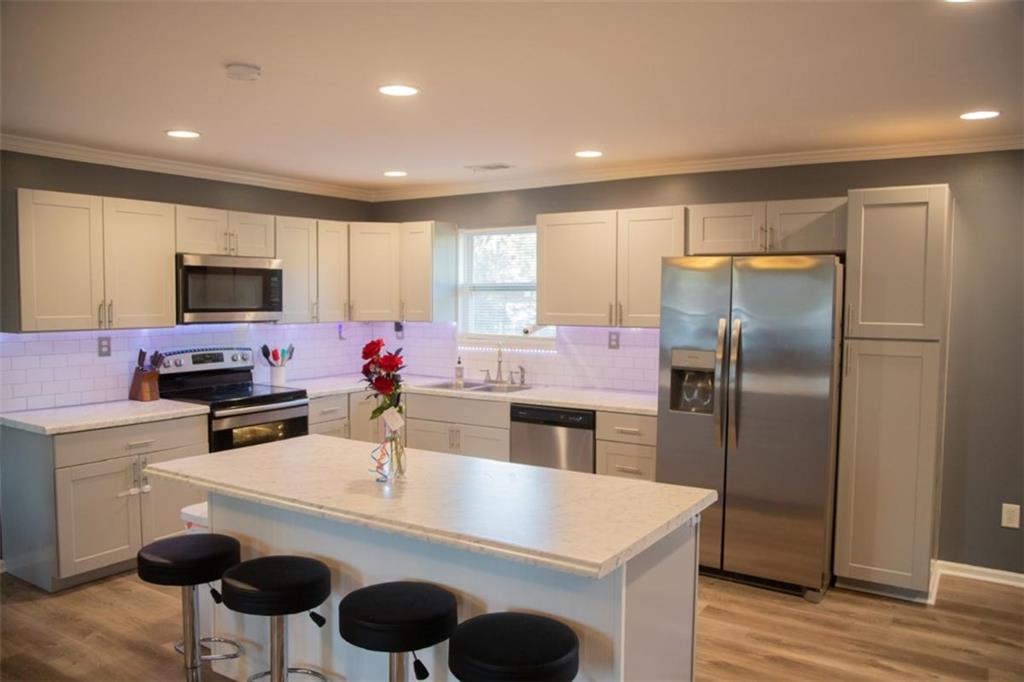 571 Oak Grove Road McDonough, GA 30253 - Photo 9 of 31 a kitchen with stainless steel appliances a stove a sink a microwave and a refrigerator