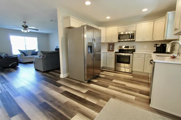 a kitchen with stainless steel appliances a refrigerator sink and microwave