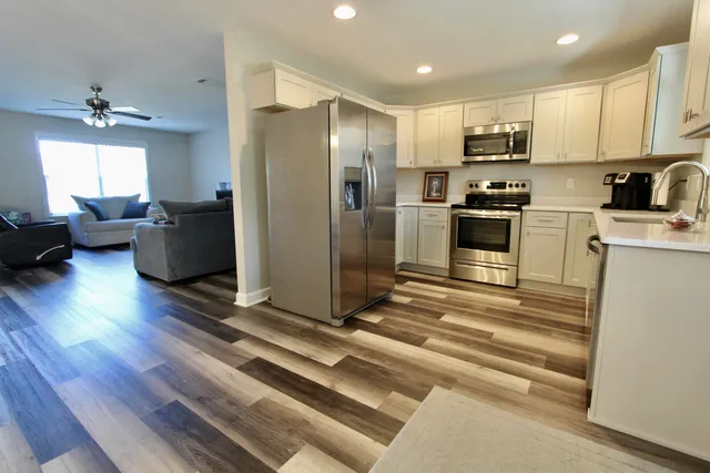 a kitchen with stainless steel appliances a refrigerator sink and microwave