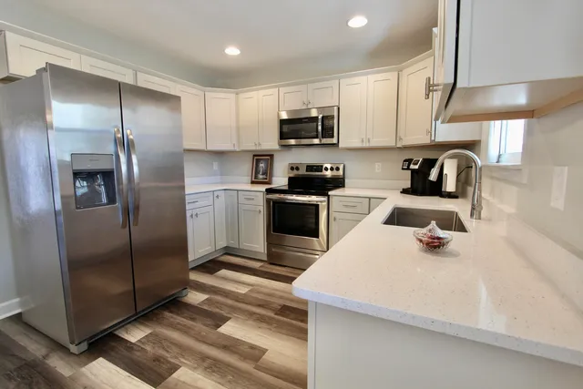 a kitchen with white cabinets sink and stainless steel appliances
