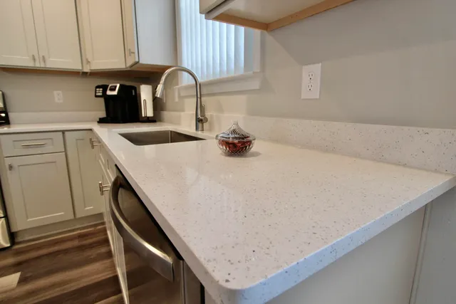 a kitchen with cabinets stainless steel appliances a sink and a window
