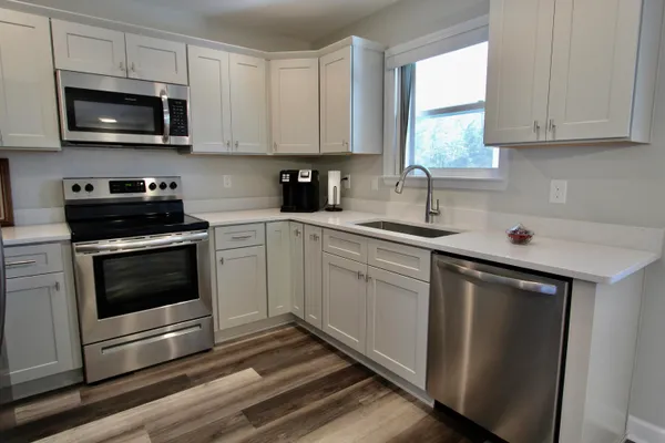 a kitchen with stainless steel appliances a sink a stove and microwave